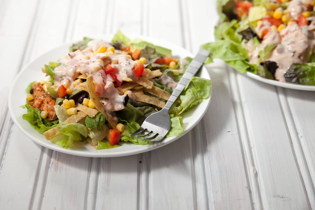 Shredded Chicken Taco Salad with Salsa Ranch-This wholesome salad is loaded with veggies like avocados, corn, and red bell peppers completed with crunchy tortilla strips, black beans, and a zesty homemade salsa ranch dressing. The shredded chicken is made completely from scratch and is so juicy and flavorful, this is a great weeknight meal that we love!