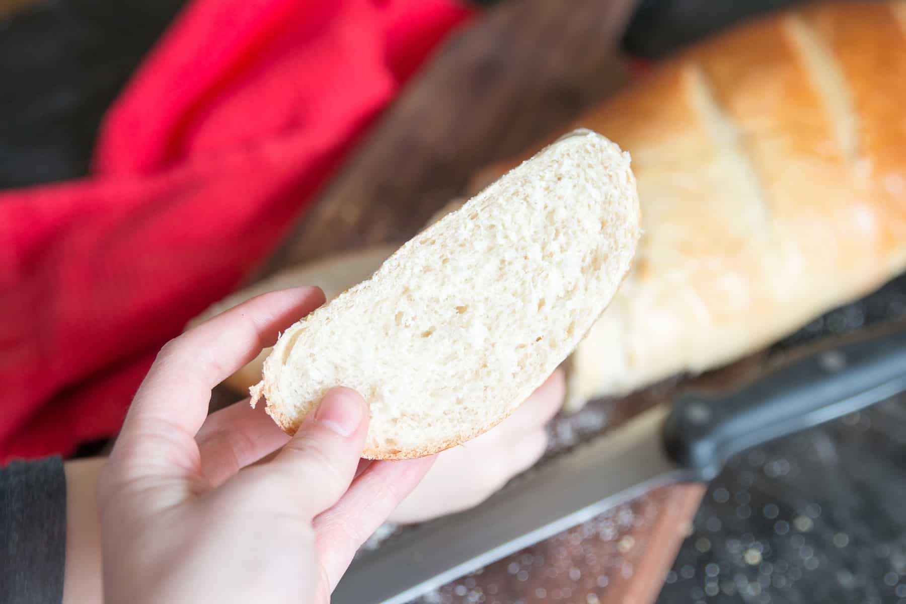 crumb shot of soft french bread with whole loaf in the background