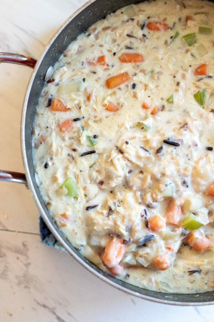 Creamy chicken and wild rice soup in pot from above