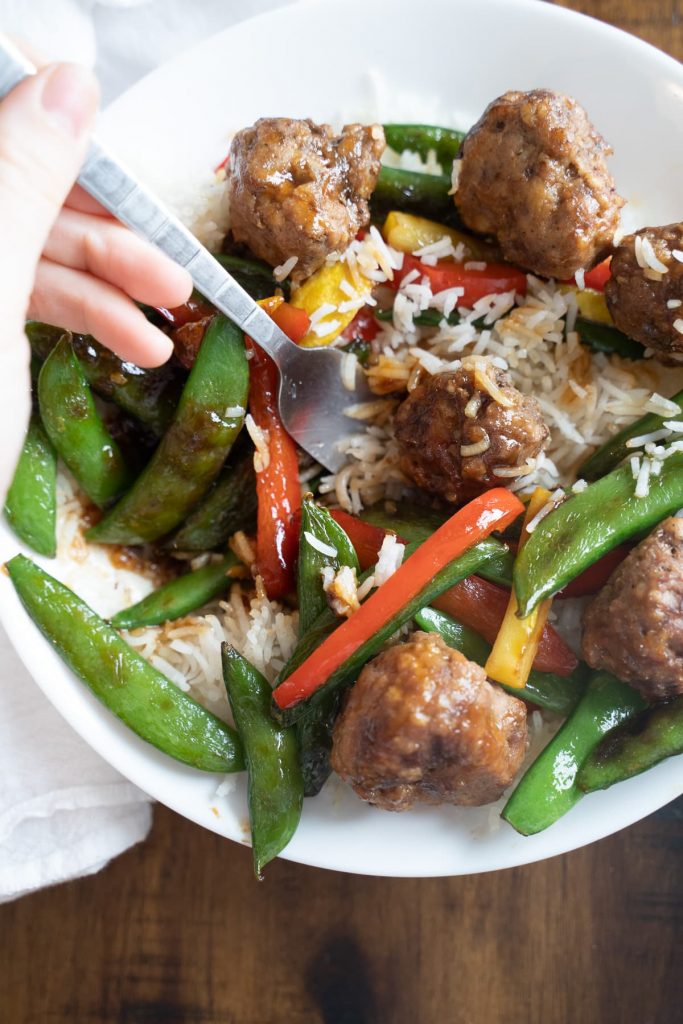 White plate with teriyaki meatball stir-fry on it