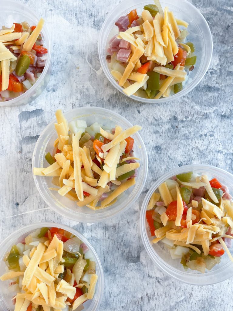 5 plastic containers of ingredients for meal prep microwave egg cups