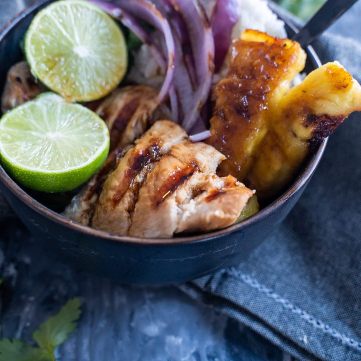 nourishing bowl with teriyaki chicken, red onion, pineapple, rice, and lime